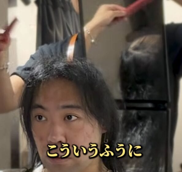 頭頂部をカバーするためトップの長さを残しながらカットする30代男性の施術中