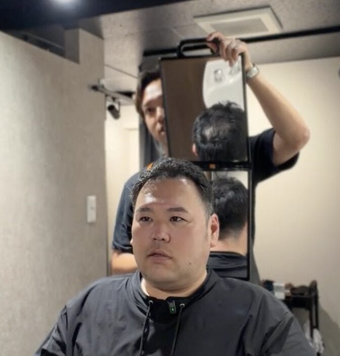 頭頂部の薄毛をカバーするためサイドを整えているM様の施術途中